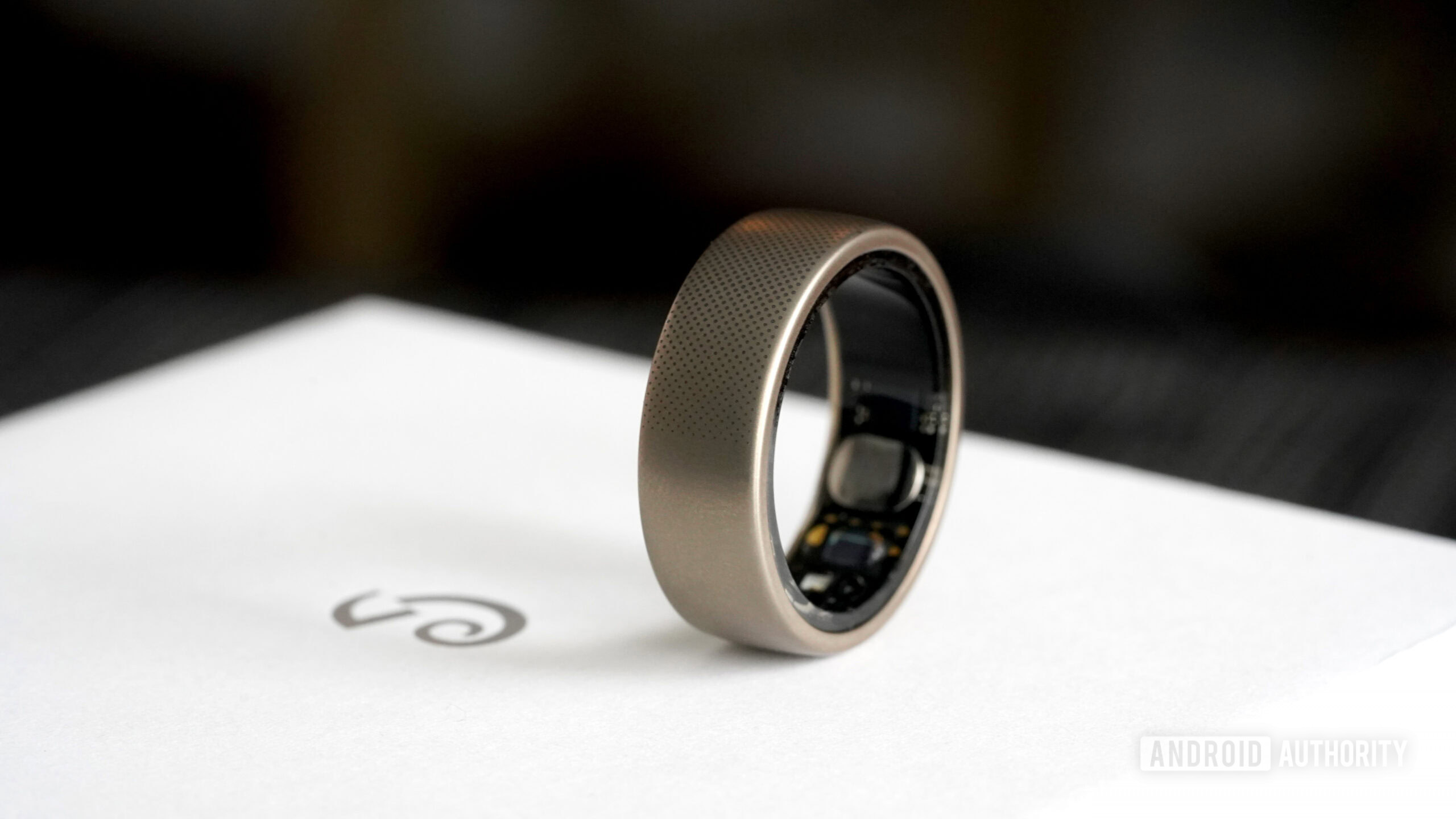 An Amazfit Helio Ring rests on a box with the Amazfit logo.