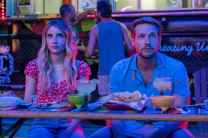 A man and woman sit next to each other at a table.