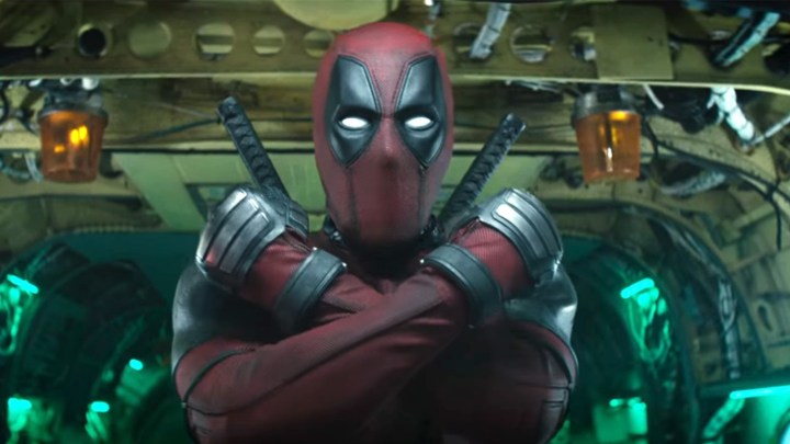 Deadpool crosses his arms as he's about to jump out of the back of an airplane.