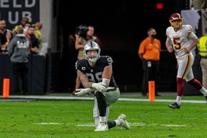 Maxx Crosby takes a knee on the football field with the Las Vegas Raiders.